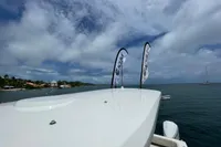 Aquila Molokai 28 boat on water, 2022 model, with flags and scenic coastal view.