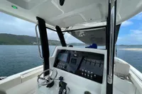 Interior view of 2022 Aquila Molokai 28 boat cockpit with steering and control panel.