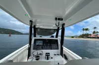 Aquila Molokai 28 boat interior, 2022 model, with steering console, on a scenic coastal waterway.