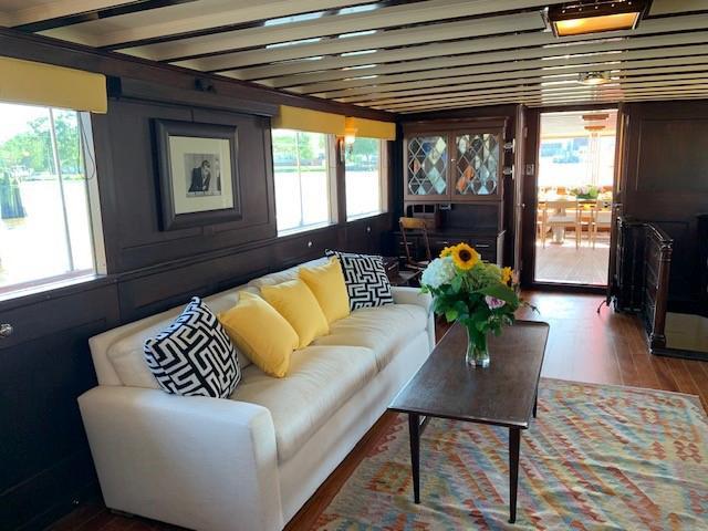 Interior of 1947 Trumpy Raised Pilot House with cozy seating and floral decor.