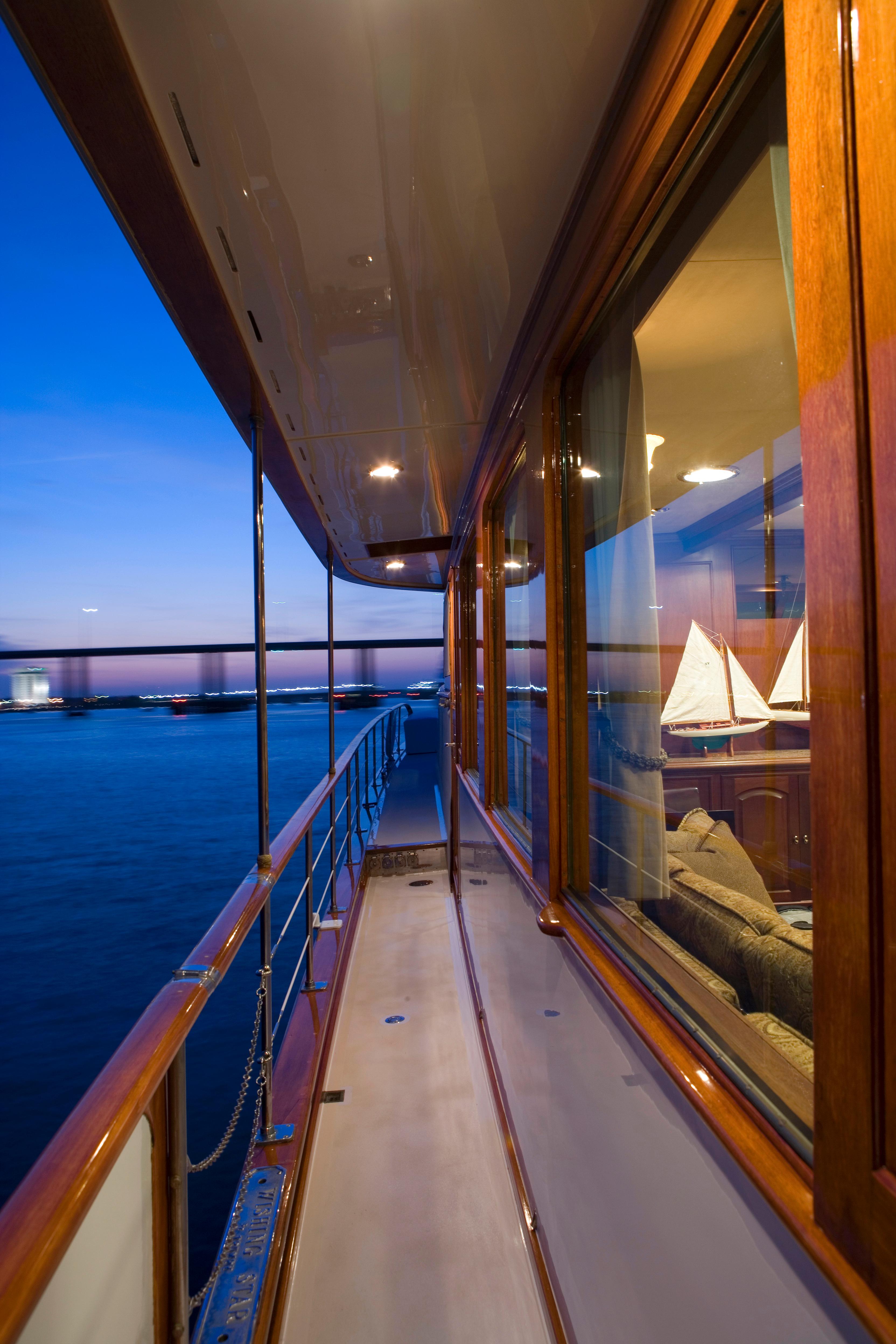 Side deck view of 1947 Trumpy Raised Pilot House yacht at sunset.