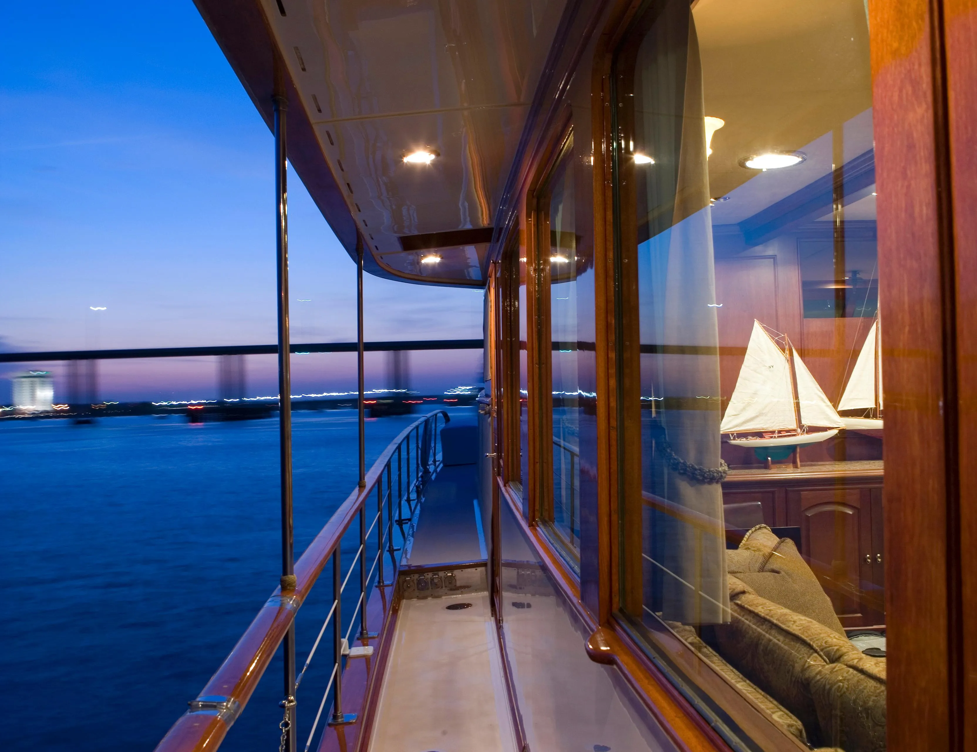 Side deck view of 1947 Trumpy Raised Pilot House yacht at sunset.