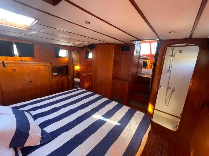 Southerly Yacht Photos Pics Luxurious 1990 Lyman-Morse 52 yacht cabin with striped bedding and wooden interior.