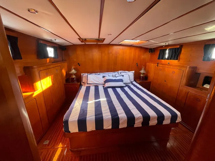 Southerly Yacht Photos Pics Luxurious cabin interior of 1990 Lyman-Morse 52 yacht with striped bedding and wooden finish.