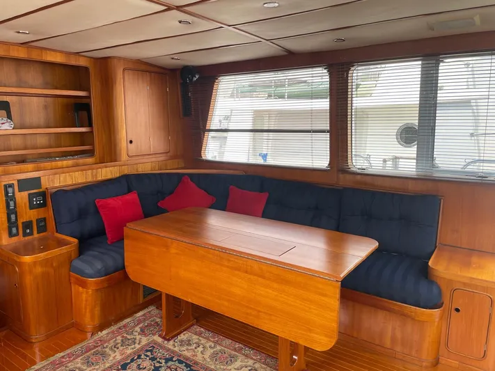 Southerly Yacht Photos Pics Interior of 1990 Lyman-Morse 52 yacht with wooden dining area and blue seating.