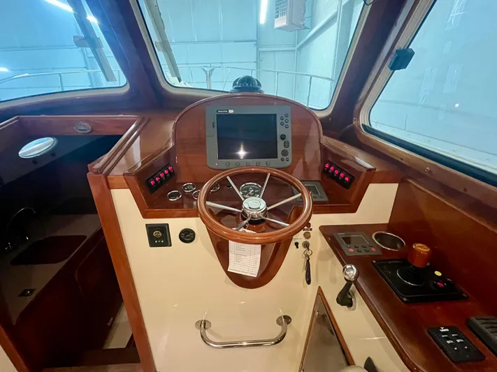  Yacht Photos Pics 2005 Hinckley Picnic Boat EP helm with wooden steering wheel and navigation controls.
