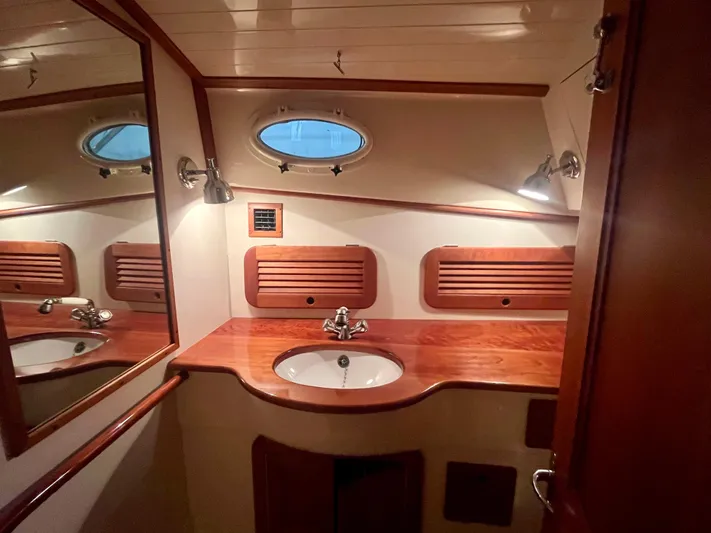  Yacht Photos Pics 2005 Hinckley Picnic Boat EP bathroom with wooden accents and porthole window.