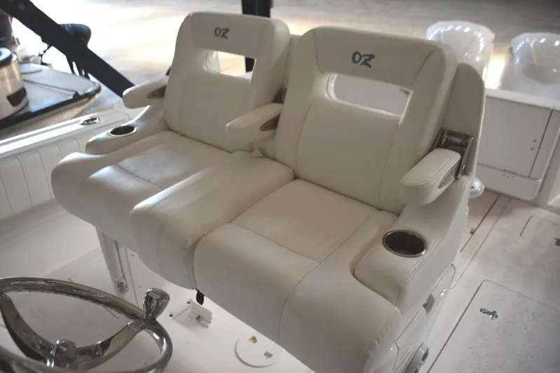 Oz Yacht Photos Pics Ocean Elite helm seat console with fold-down armrests and drink holders.