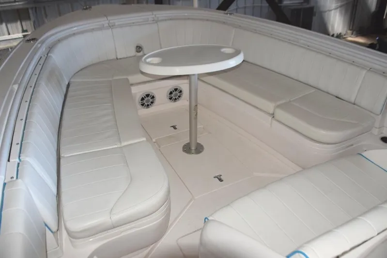 Oz Yacht Photos Pics Forward seating and fiberglass table with drink holders. Storage compartments behind backrests.