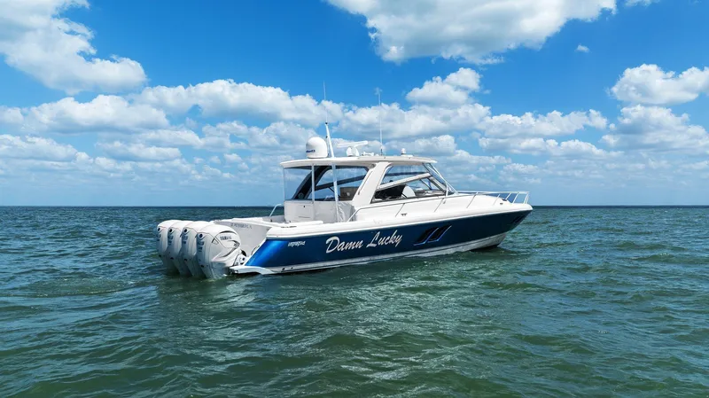Damn Lucky Yacht Photos Pics 2019 Intrepid 475 boat on open water under a blue sky with clouds.
