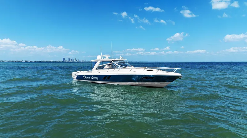 Damn Lucky Yacht Photos Pics 2019 Intrepid 475 boat cruising on open water under a clear blue sky.