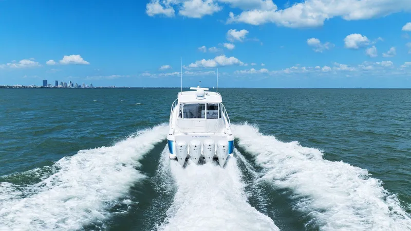 Damn Lucky Yacht Photos Pics 2019 Intrepid 475 boat cruising on open water under a clear blue sky.
