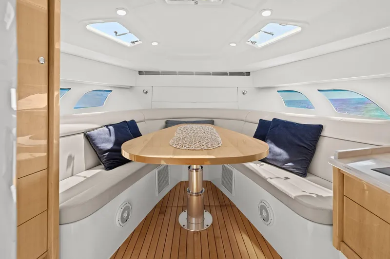 Damn Lucky Yacht Photos Pics Luxurious interior of 2019 Intrepid 475 yacht with elegant seating and table.