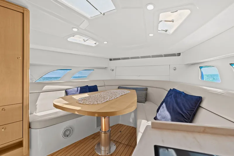 Damn Lucky Yacht Photos Pics Luxurious interior of 2019 Intrepid 475 yacht with elegant seating and wooden table.