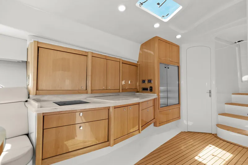 Damn Lucky Yacht Photos Pics Luxurious 2019 Intrepid 475 yacht interior with modern kitchen and wooden cabinetry.