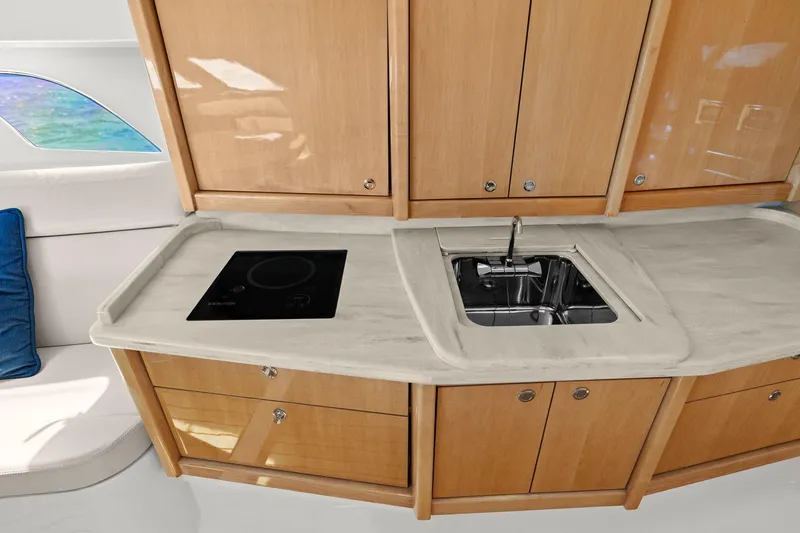 Damn Lucky Yacht Photos Pics Modern kitchen area in a 2019 Intrepid 475 yacht with stove and sink.