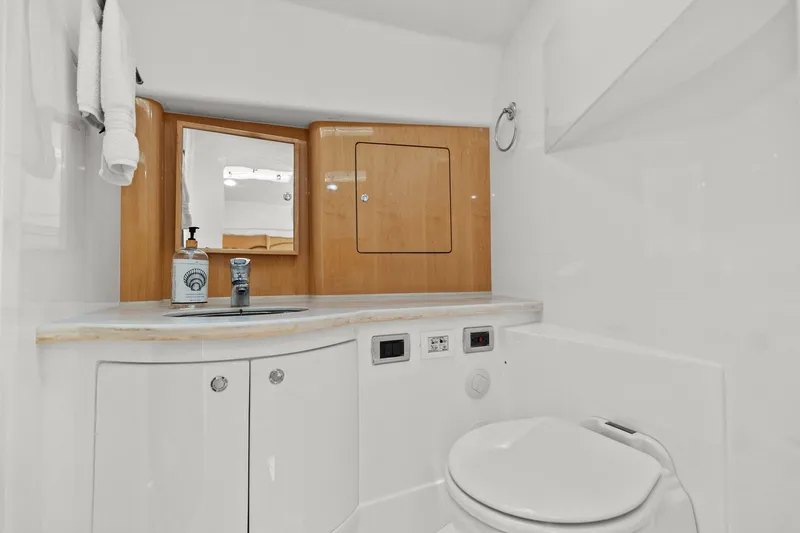 Damn Lucky Yacht Photos Pics Luxurious bathroom in 2019 Intrepid 475 yacht with modern fixtures and wooden cabinetry.
