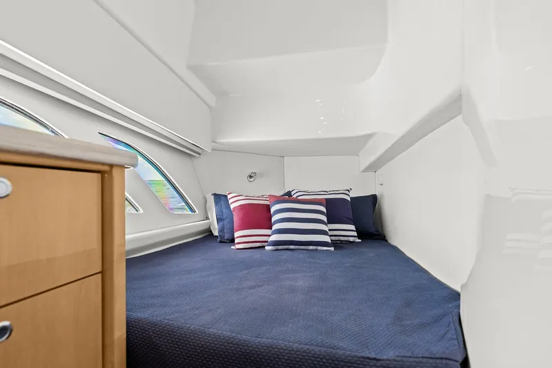 Damn Lucky Yacht Photos Pics 2019 Intrepid 475 cabin interior with cozy bed and striped pillows.