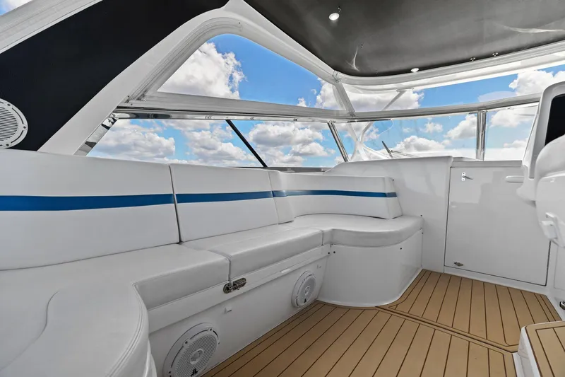 Damn Lucky Yacht Photos Pics Luxurious 2019 Intrepid 475 yacht interior with white seating and blue accents under a clear sky.