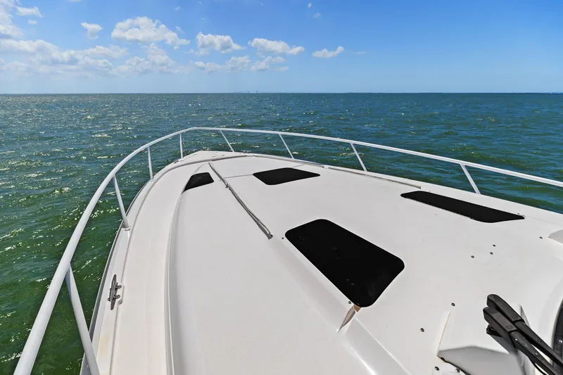 Damn Lucky Yacht Photos Pics Bow view of 2019 Intrepid 475 yacht cruising on open sea under clear skies.
