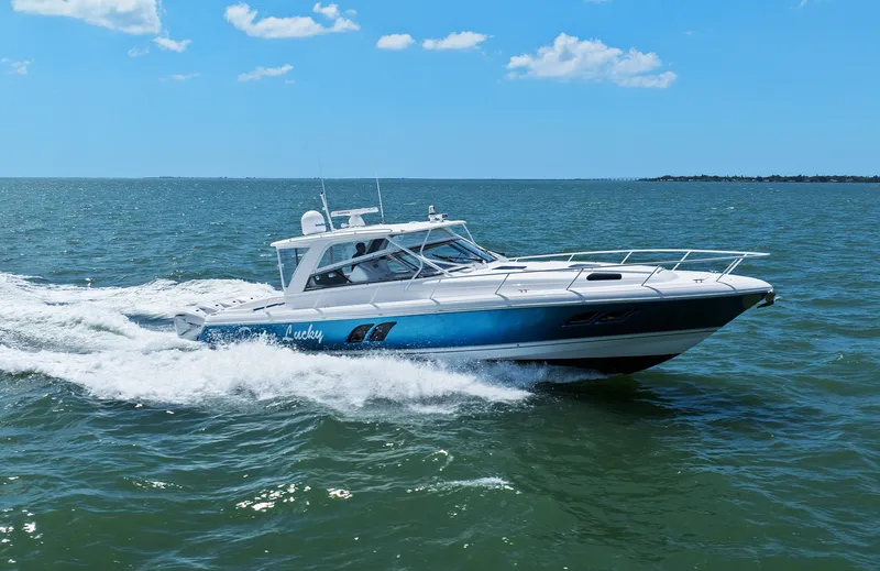 Damn Lucky Yacht Photos Pics 2019 Intrepid 475 boat cruising on open water under a clear blue sky.