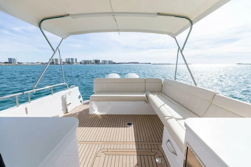New Mjm 4 Yacht Photos Pics Luxurious MJM 4 yacht deck with seating, overlooking serene ocean and distant cityscape, 2025 model.