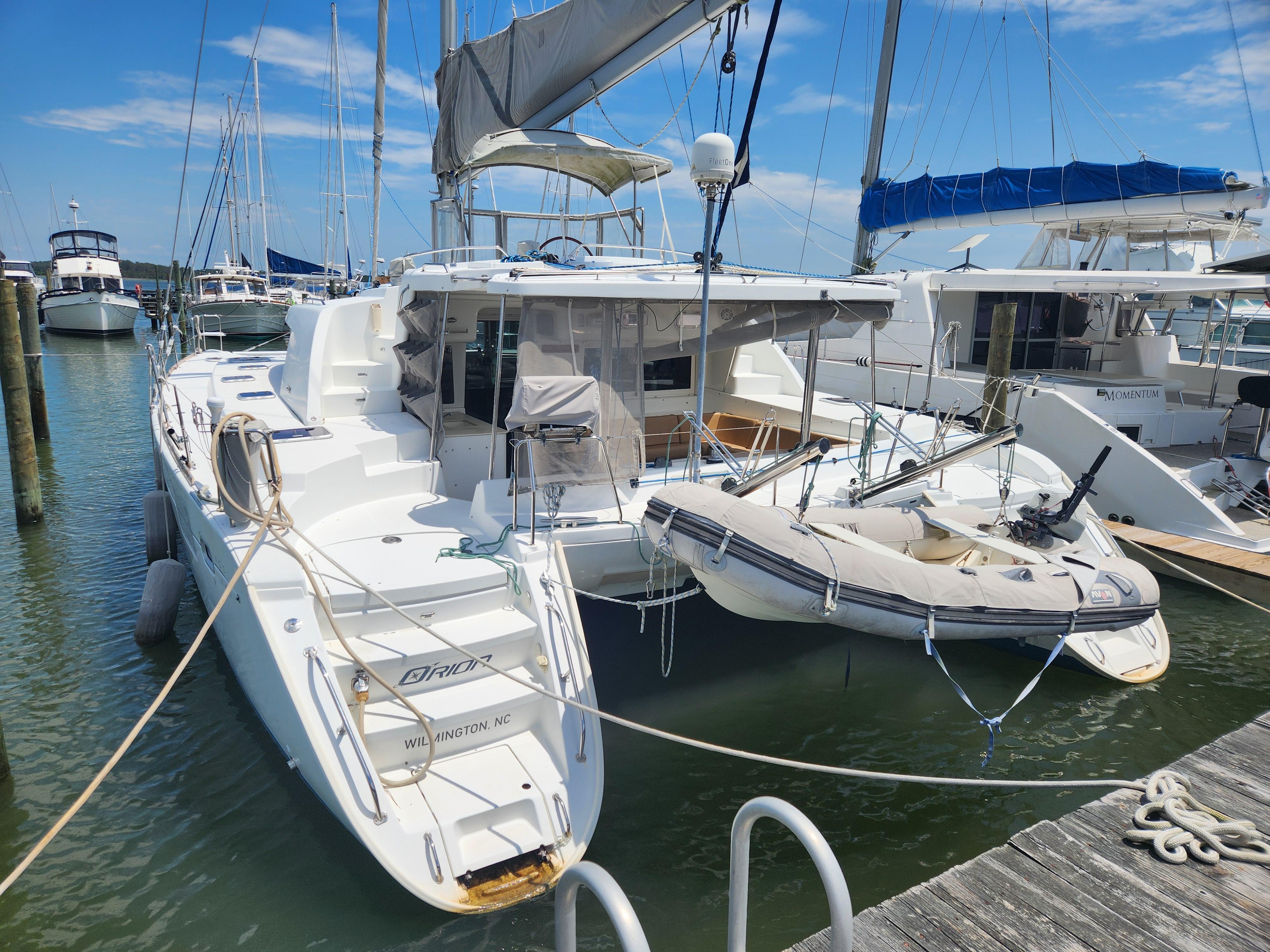 2006 Lagoon 440 catamaran docked at marina with inflatable dinghy attached.