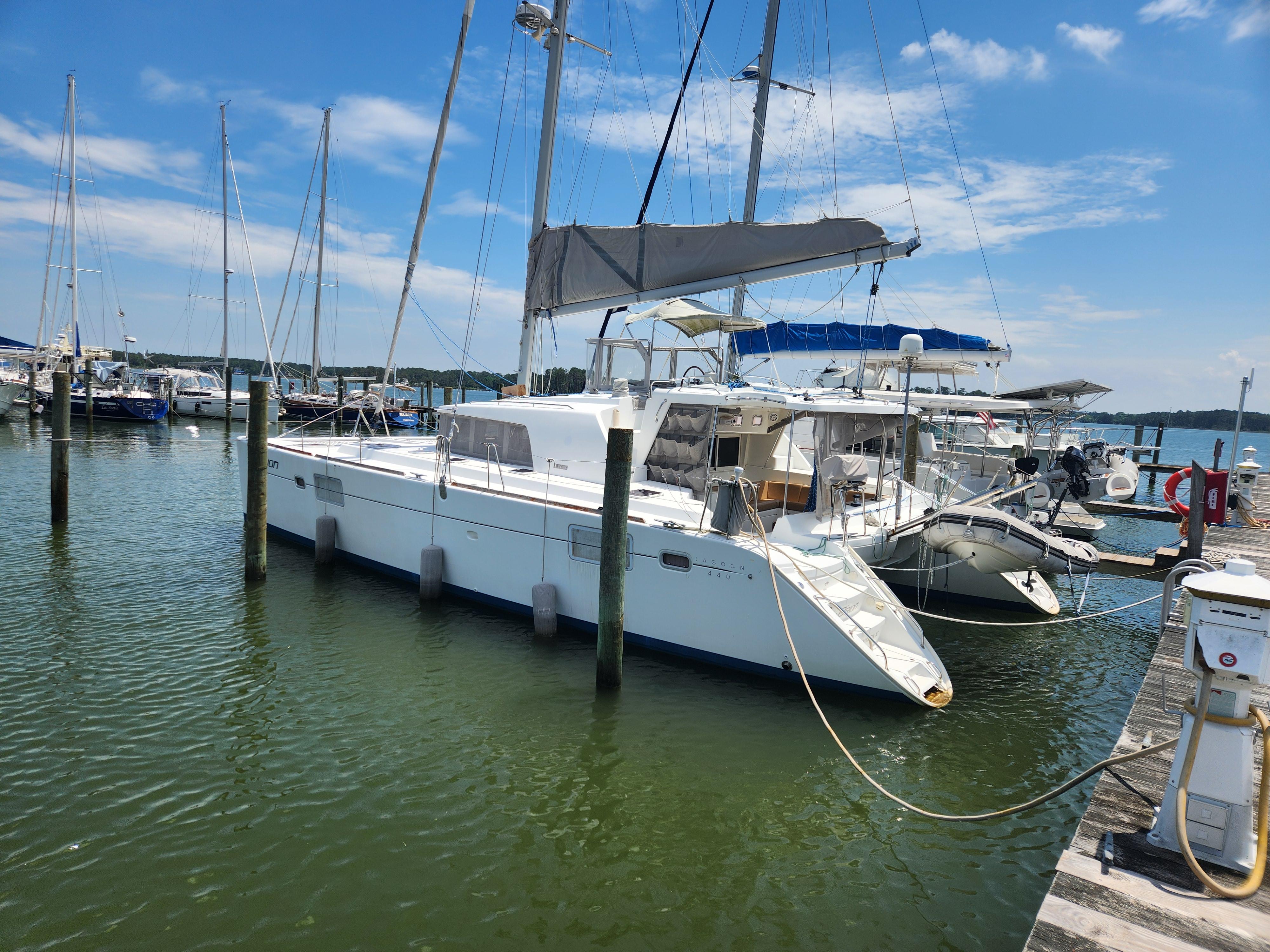 2006 Lagoon 440 catamaran docked at a marina under a clear blue sky.
