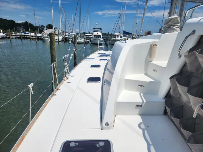 Orion Yacht Photos Pics Lagoon 440 catamaran deck view, 2006 model, docked in a marina under clear skies.