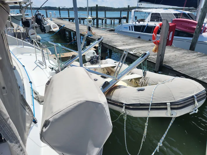 Orion Yacht Photos Pics 2006 Lagoon 440 catamaran docked with inflatable dinghy, marina background.