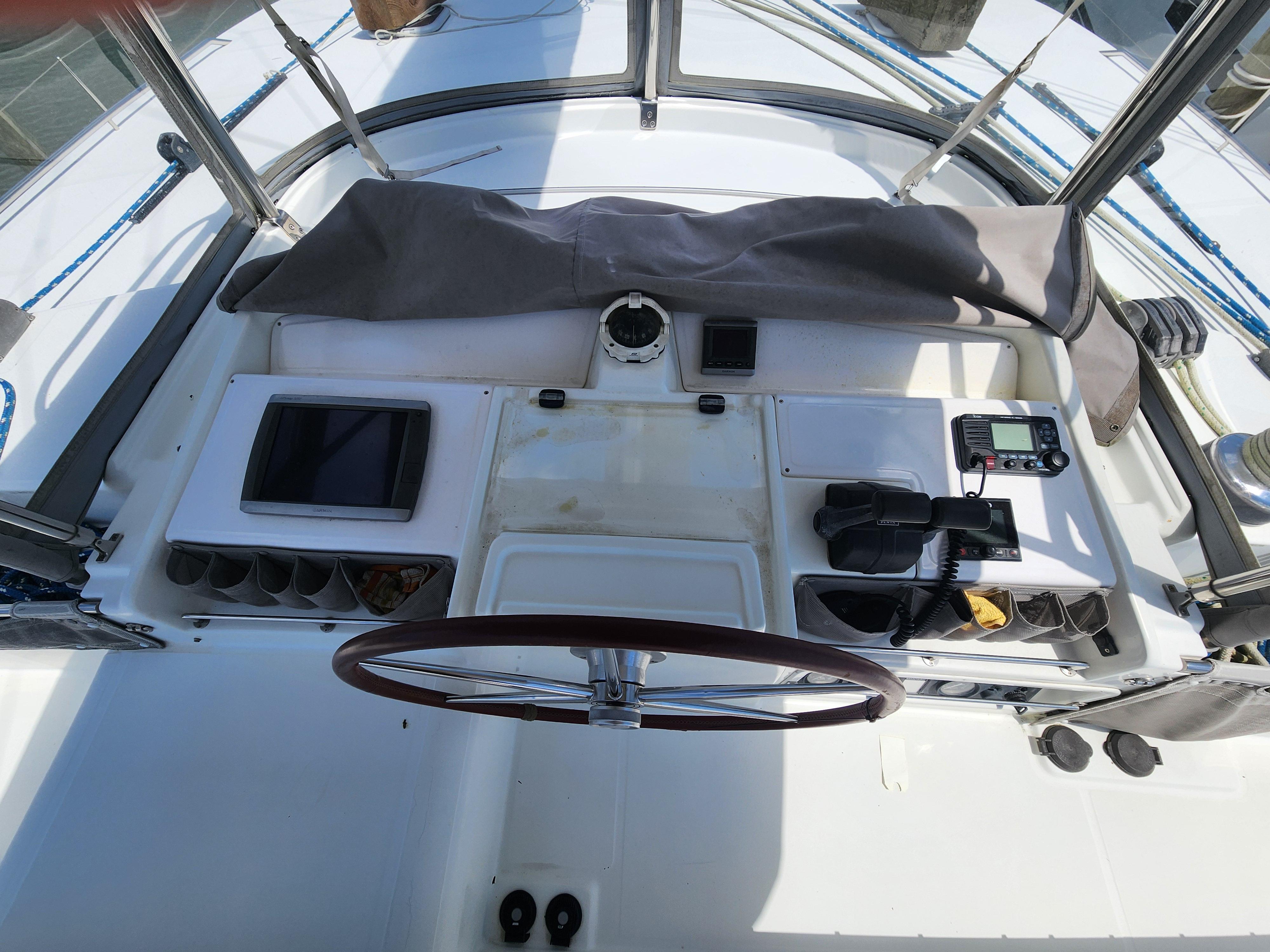 Helm station of 2006 Lagoon 440 catamaran with navigation equipment and steering wheel.