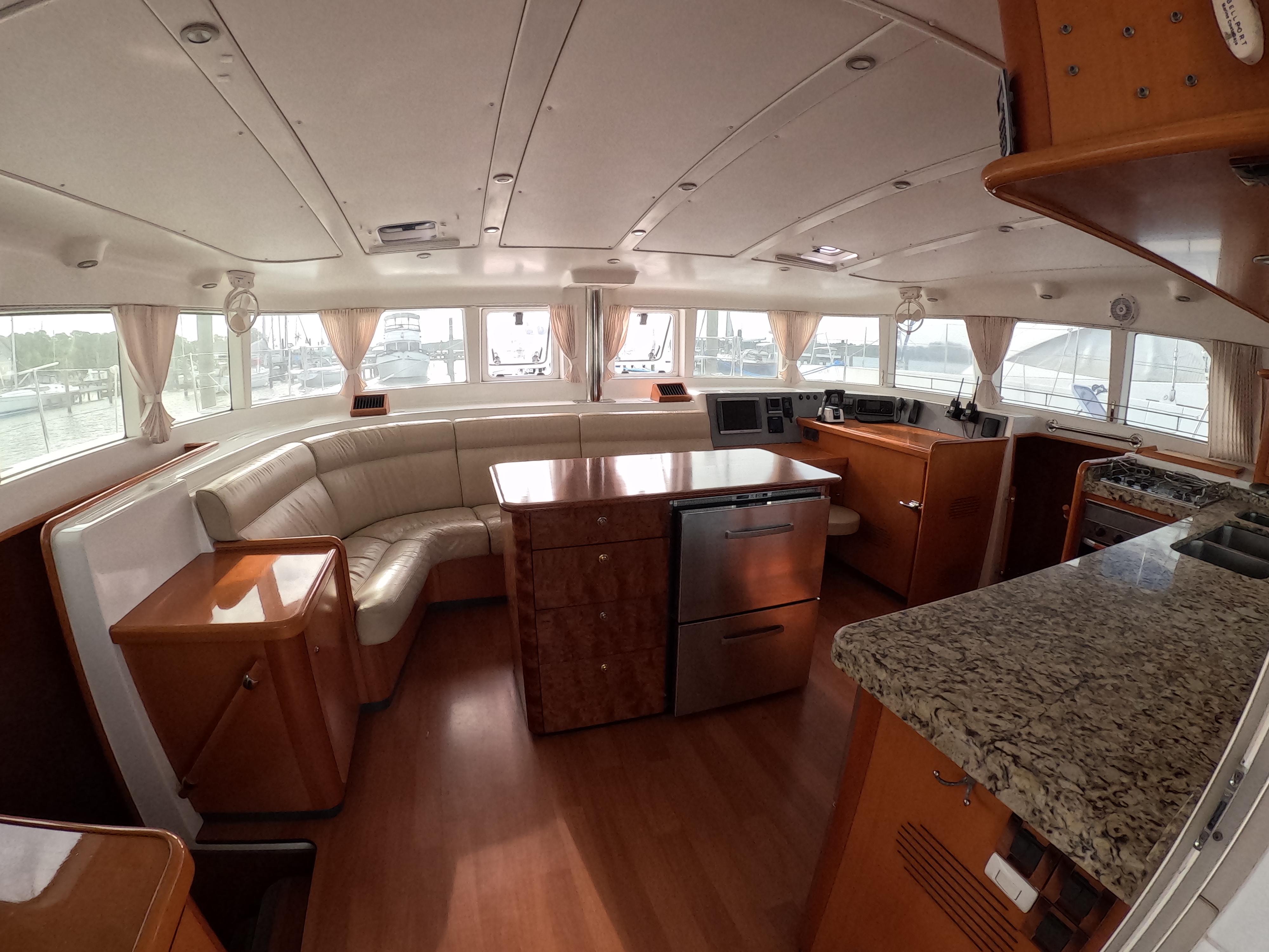 Interior of 2006 Lagoon 440 catamaran with spacious seating, modern kitchen, and elegant wood finishes.