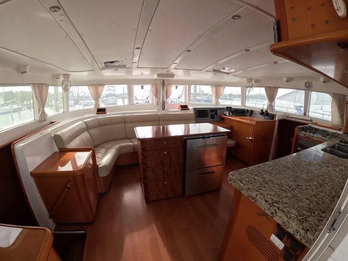 Orion Yacht Photos Pics Interior of 2006 Lagoon 440 catamaran with spacious seating, modern kitchen, and elegant wood finishes.