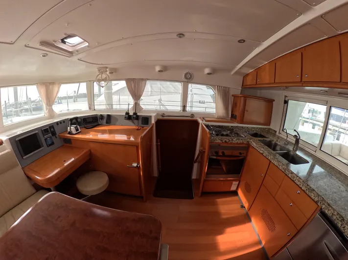Orion Yacht Photos Pics Interior of 2006 Lagoon 440 catamaran with wood finish and modern kitchen amenities.