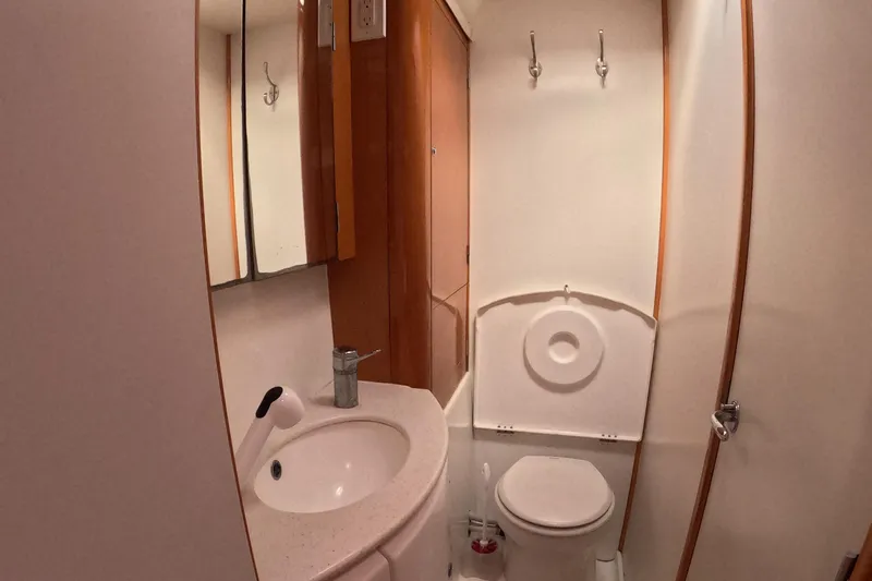 Orion Yacht Photos Pics Bathroom interior of 2006 Lagoon 440 yacht, featuring sink, mirror, and toilet.