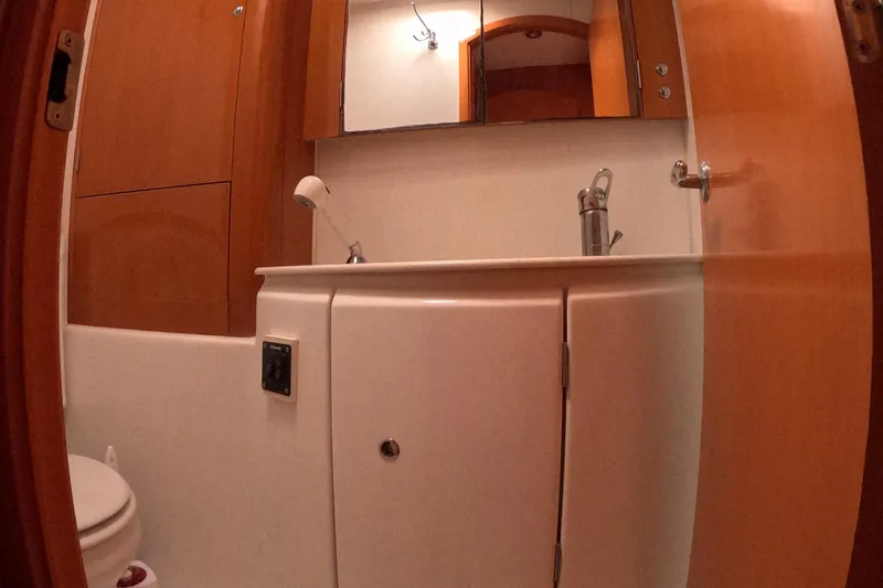 Orion Yacht Photos Pics Bathroom interior of 2006 Lagoon 440 yacht with wooden cabinetry and modern fixtures.