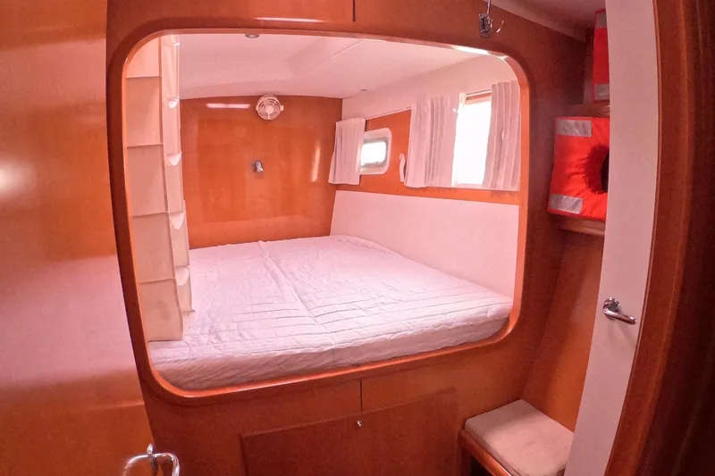 Orion Yacht Photos Pics Cozy cabin interior of 2006 Lagoon 440 catamaran with bed and porthole windows.