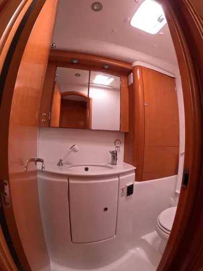 Orion Yacht Photos Pics 2006 Lagoon 440 yacht bathroom with wooden cabinetry, sink, and mirror.