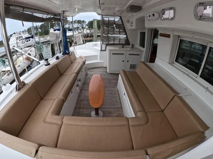 Orion Yacht Photos Pics Spacious seating area on a 2006 Lagoon 440 catamaran, docked at a marina.