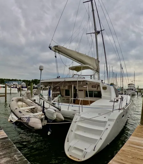 Orion Yacht Photos Pics 2006 Lagoon 440 catamaran docked at marina with inflatable dinghy attached.