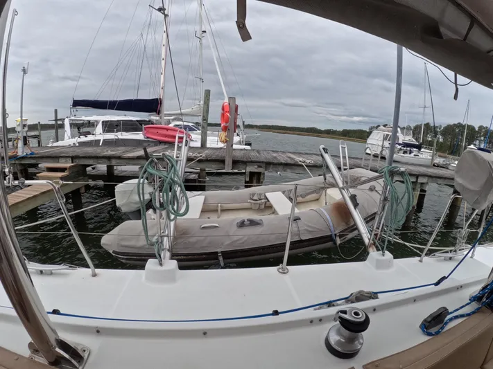 Orion Yacht Photos Pics 2006 Lagoon 440 catamaran docked with inflatable dinghy, overcast sky, marina setting.