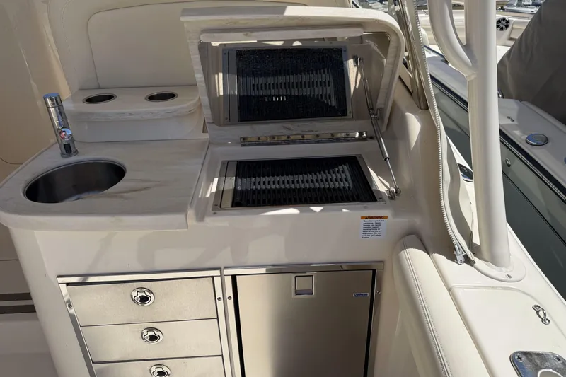 335-714 Used Yacht Photos Pics Outdoor kitchen on 2021 Grady-White Freedom 335 boat with sink, grill, and storage.