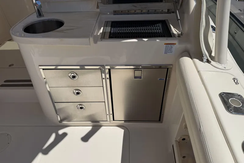 335-714 Used Yacht Photos Pics 2021 Grady-White Freedom 335 boat interior with sink, grill, and storage drawers.