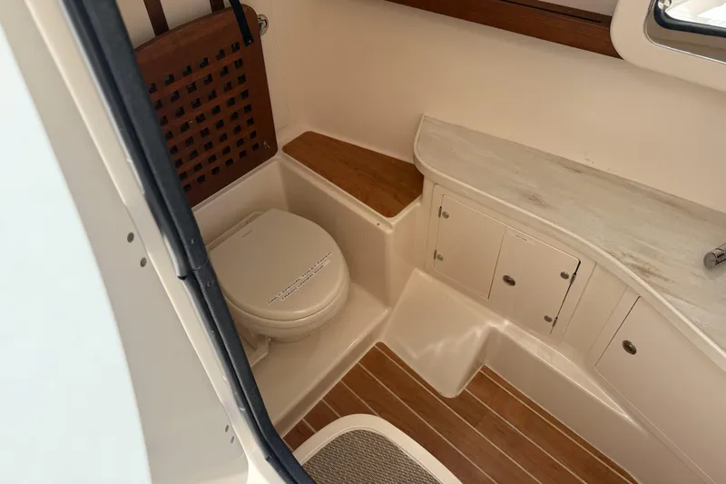 335-714 Used Yacht Photos Pics 2021 Grady-White Freedom 335 boat interior with toilet and storage cabinets.