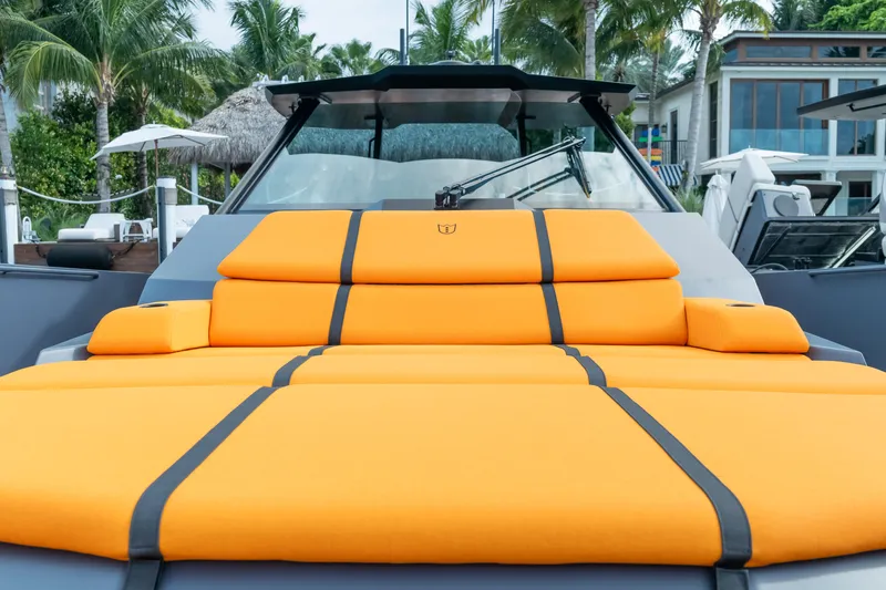  Yacht Photos Pics Luxurious 2024 Lekker 44 yacht with vibrant orange seating, docked near palm trees.