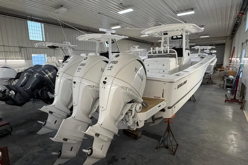 White Yacht Photos Pics 2024 Regulator 34 boat with triple Yamaha engines in a storage facility.