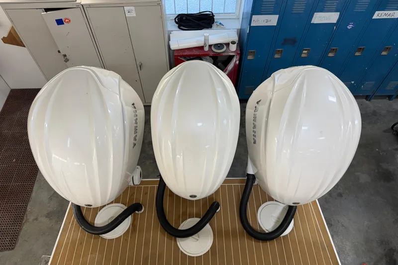 White Yacht Photos Pics Three Yamaha outboard motor covers in a workshop, viewed from above.