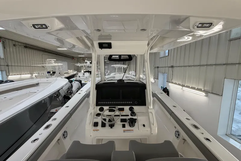 White Yacht Photos Pics 2024 Regulator 34 boat interior with modern helm and controls in a showroom.