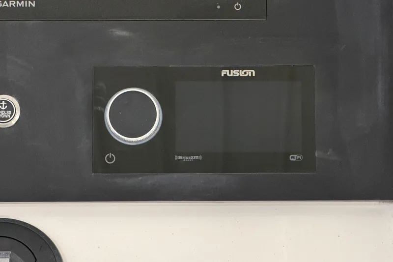 White Yacht Photos Pics 2024 Regulator 34 boat dashboard featuring Fusion audio system and Garmin controls.