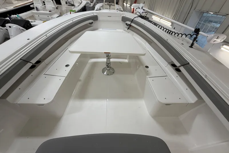 White Yacht Photos Pics 2024 Regulator 34 boat interior with seating and table in a showroom.